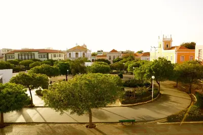 a park with trees and buildings in a city at Hotel Praia Confort in Praia