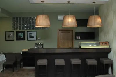 a bar in a restaurant with two lights and stools at Hotel Praia Confort in Praia