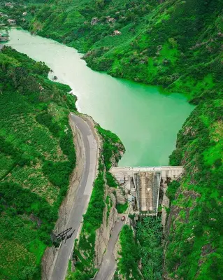 a road on the side of a mountain next to a river at Pam de Terra in Palha Carga