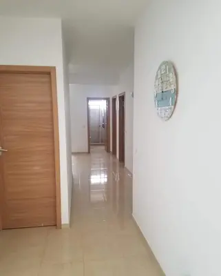 a hallway with a door and a clock on the wall at Lovely - Luxury 2 Bedrooms 500m from the Beach in Santa Maria