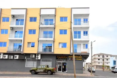 a yellow building with a car parked in front of it at Lovely - Luxury 2 Bedrooms 500m from the Beach in Santa Maria