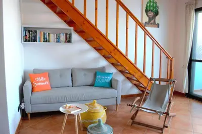 a living room with a couch and a staircase at Time Out Pátio Antigo AC Wifi in Santa Maria