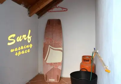 a room with a surfboard on the wall next to a wall at Time Out Pátio Antigo AC Wifi in Santa Maria