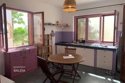 a kitchen with a table and a sink and windows at BookingBoavista - Apartments in Sal Rei