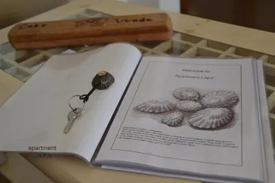 a book with a key on top of it next to a bookocument at BookingBoavista - Apartments in Sal Rei
