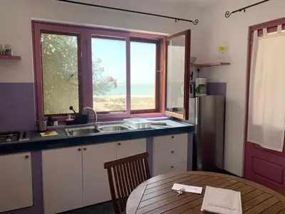 a kitchen with a sink and a table and a window at BookingBoavista - Apartments in Sal Rei