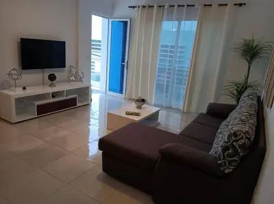 a living room with a couch and a flat screen tv at New, Modern, and Cozy 3 Bedroom Apartment. in Santa Maria