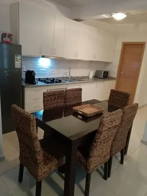 a kitchen with a table with chairs and a refrigerator at New, Modern, and Cozy 3 Bedroom Apartment. in Santa Maria