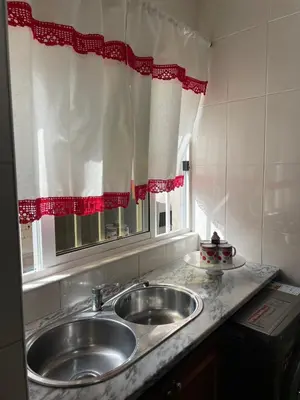 a kitchen counter with a sink and a window at Apartamentos Avenida in Praia