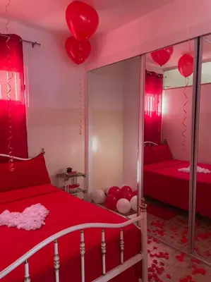 a bedroom with red and white balloons hanging from the ceiling at Apartamentos Avenida in Praia