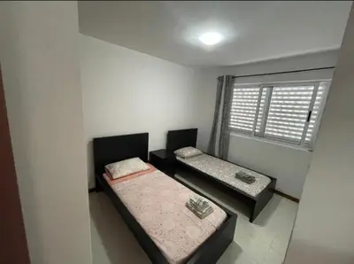 two beds in a room with a window at Apartamento Vila Santa Bárbara ,Bloco F RChão Dirt,Santo Antão,Cabo Verde in Mão para Trás