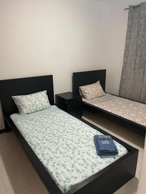 two beds in a room with a book on them at Apartamento Vila Santa Bárbara ,Bloco F RChão Dirt,Santo Antão,Cabo Verde in Mão para Trás
