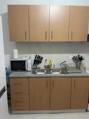 a kitchen with a sink and a microwave at Apartamento Vila Santa Bárbara ,Bloco F RChão Dirt,Santo Antão,Cabo Verde in Mão para Trás