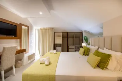 a bedroom with a large bed with a green blanket at Luna Boutique Hotel in Mindelo