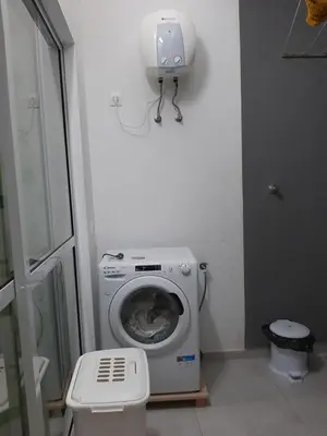 a washing machine in a bathroom next to a toilet at Núria's Apartment in Mindelo