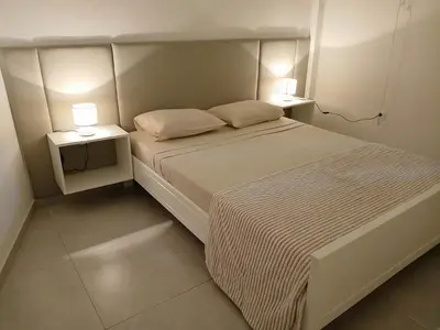 a bedroom with a white bed with two night stands at Núria's Apartment in Mindelo