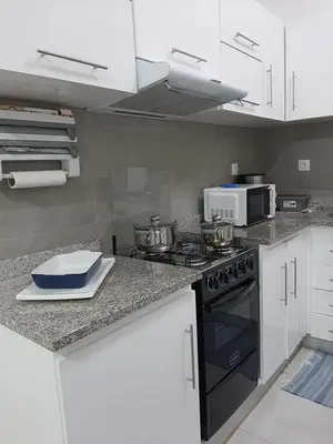 a kitchen with a stove and a microwave at Núria's Apartment in Mindelo