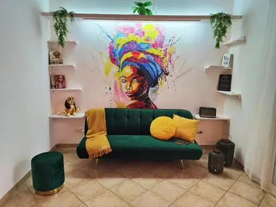 a living room with a green couch in front of a painting at Cacau's Home - By Albis Harena in Santa Maria