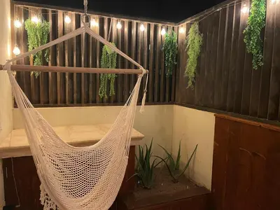a swinging hammock in a room with plants at Cacau's Home - By Albis Harena in Santa Maria