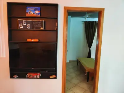 a living room with a tv and a mirror at Cacau's Home - By Albis Harena in Santa Maria