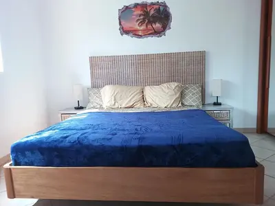 a bedroom with a bed with a blue comforter and two lamps at Relaxed Home to calm in Santa Maria