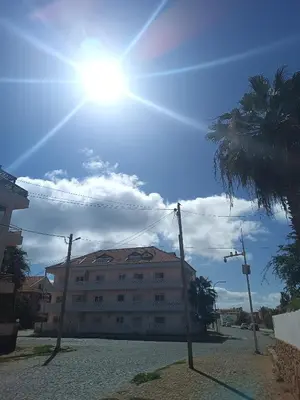 a building on a street with the sun in the sky at Relaxed Home to calm in Santa Maria