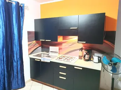 a kitchen with black cabinets and a sink and a stove at Relaxed Home to calm in Santa Maria