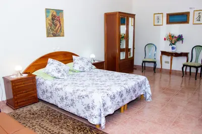 a bedroom with a bed and a table and chairs at Residencial Chez Flor in Porto Novo