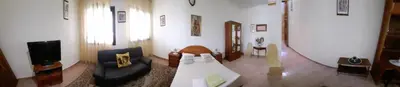 a living room with a couch and a tv at Residencial Chez Flor in Porto Novo