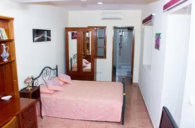 a bedroom with a bed and a walk in shower at Residencial Chez Flor in Porto Novo