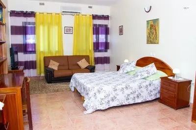 a bedroom with a bed and a couch at Residencial Chez Flor in Porto Novo