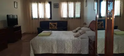 a bedroom with a bed and a couch and a tv at Residencial Chez Flor in Porto Novo