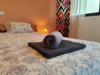 a rolled up towel sitting on top of a bed at Kyaala Suítes - pool & sea view in Praia
