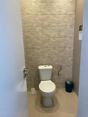 a bathroom with a white toilet in a stall at Kyaala Suítes - pool & sea view in Praia