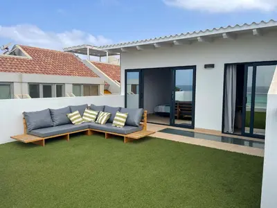 a patio with a couch on a green lawn at New Rooftop Gem with stunning Oceanview in Santa Maria