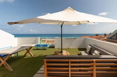 a patio with an umbrella and a table and chairs at New Rooftop Gem with stunning Oceanview in Santa Maria