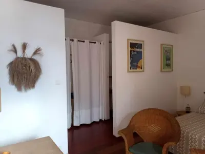a room with a bedroom with a bed and a chair at Casa Azul in Mindelo