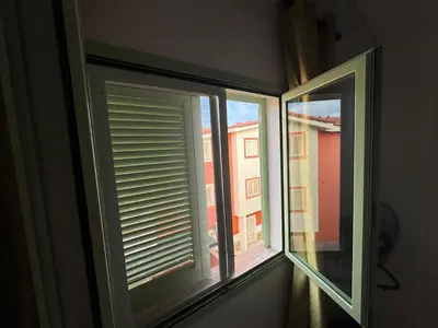 a window with a view of a building at Holiday Properties Moradias Green in Santa Maria