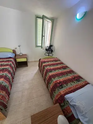 a bedroom with two beds with a blanket on the floor at Holiday Properties Moradias Green in Santa Maria