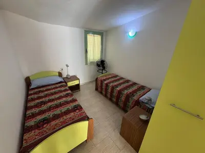 a small bedroom with two beds and a window at Holiday Properties Moradias Green in Santa Maria