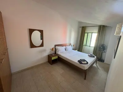 a bedroom with a bed and a mirror on the wall at Holiday Properties Moradias Green in Santa Maria