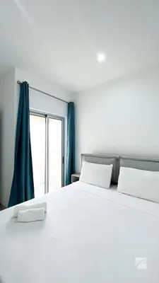 a bedroom with a large white bed with a window at Ka Djula in Sal Rei