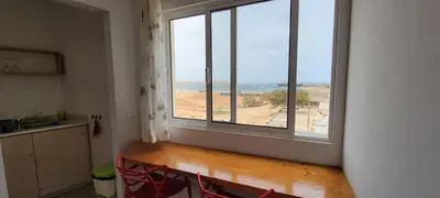a room with a large window with a view of the ocean at Baia Palmeira Residence in Palmeira