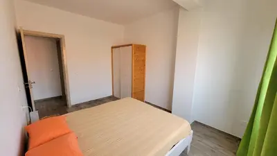 a small bedroom with a bed and a cabinet at Baia Palmeira Residence in Palmeira