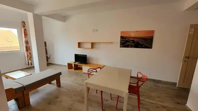 a living room with a table and a dining room at Baia Palmeira Residence in Palmeira