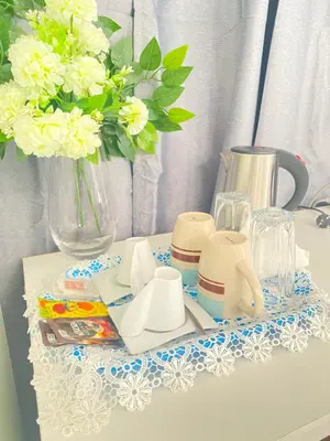 a table with a tea set and a vase with flowers at Best Rooms - Quarto 3 Plateau in Praia