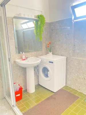 a bathroom with a washing machine and a sink at Best Rooms - Quarto 3 Plateau in Praia