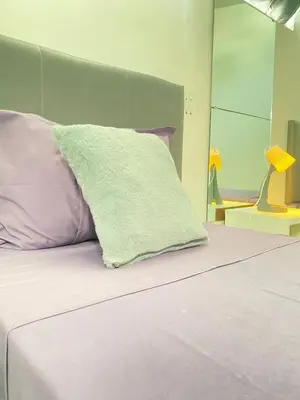 a bed with a green pillow on top of it at Best Rooms- Quarto 2 Plateau in Praia
