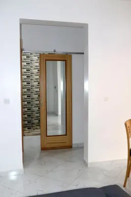a hallway with a wooden door with a mirror at Figo Apartamentos Cidadela Comfort Flats in Praia