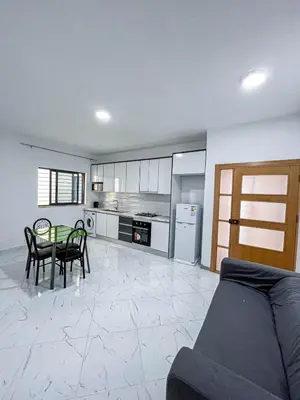 a living room with a table and a kitchen at Figo Apartamentos Cidadela Comfort Flats in Praia